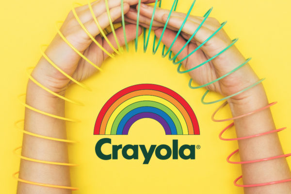 Crayola wordmark with rainbow under hands inside a slinky for retro-themed creative assets.